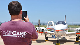 Man photographing a twin propeller plane