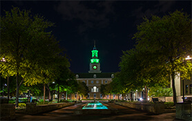 Night photo of McConnell Tower illuminated in green
