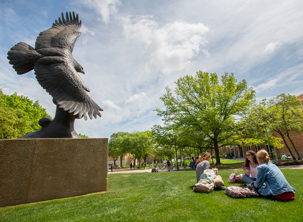 Students on the UNT campus near the eagle statue