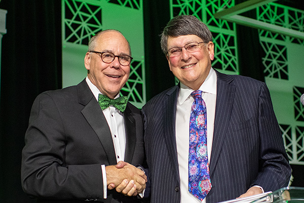 UNT President Neal Smatresk shakes hands with Jerome Max Westheimer Jr at the 2019 Wingspan event