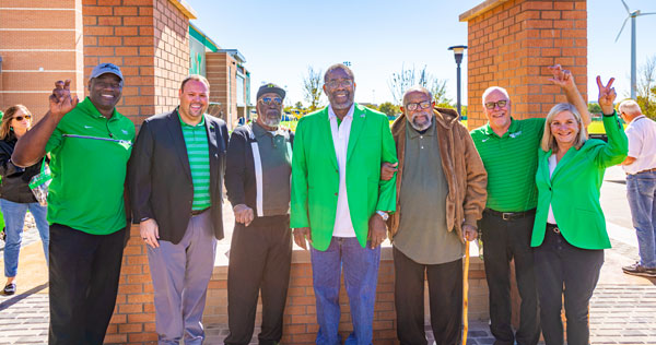 Denton Mayor Gerard Hudspeth, Vice President and Director of Athletics Wren Baker, Abner Haynes, Joe Greene, Leon King, UNT President Neal Smatresk and UNT System Board of Regents Chair Laura Wright pose for a photo at the dedication of Unity Plaza.