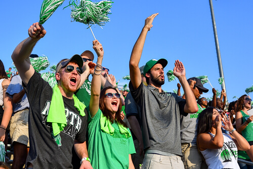 UNT fans cheer from the stands at a football game